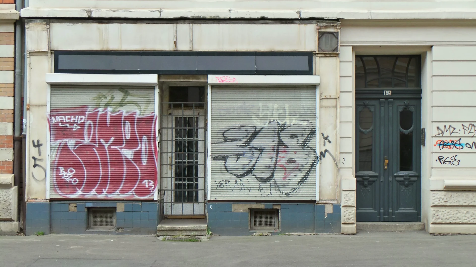 Abandoned storefront covered in graffiti.