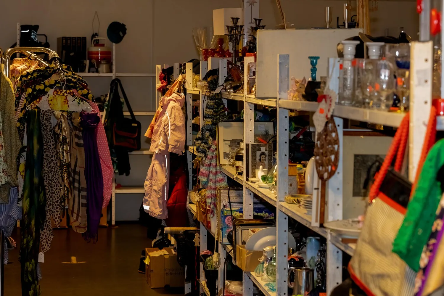Cluttered thrift store packed with overflowing shelves.