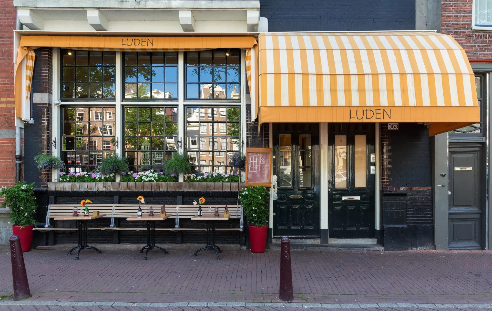 Welcoming café with striped awning, benches, and flowers.