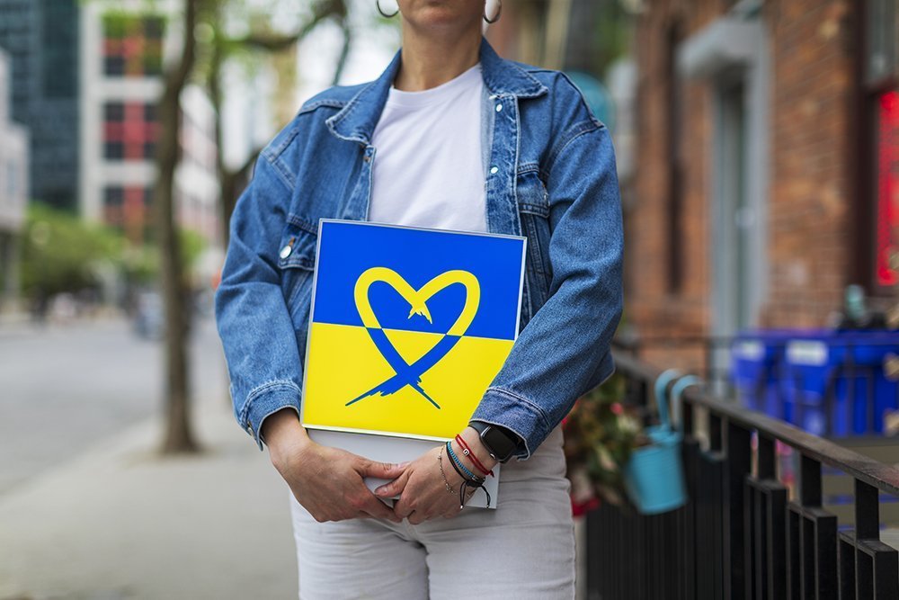 A woman holding a Freedom Heart Ukraine lightbox