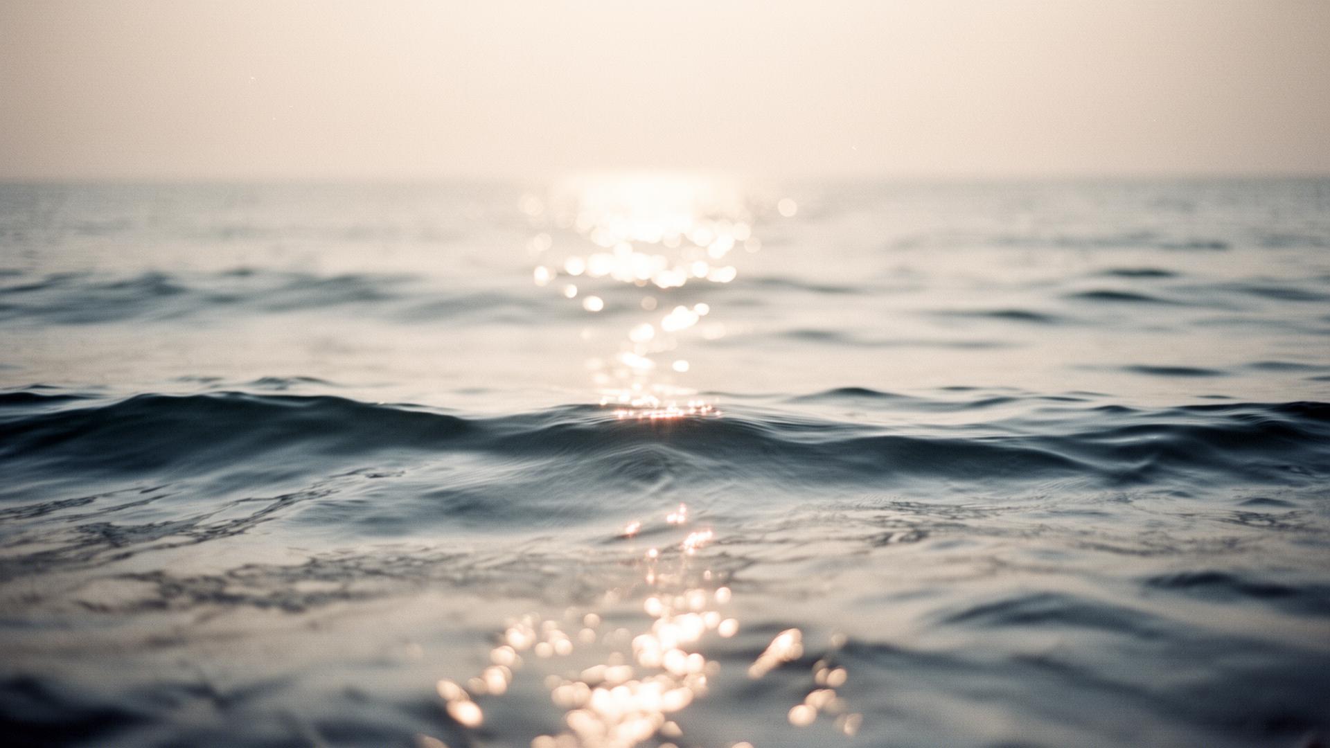 Soft bokeh light on quiet ocean waves at dawn